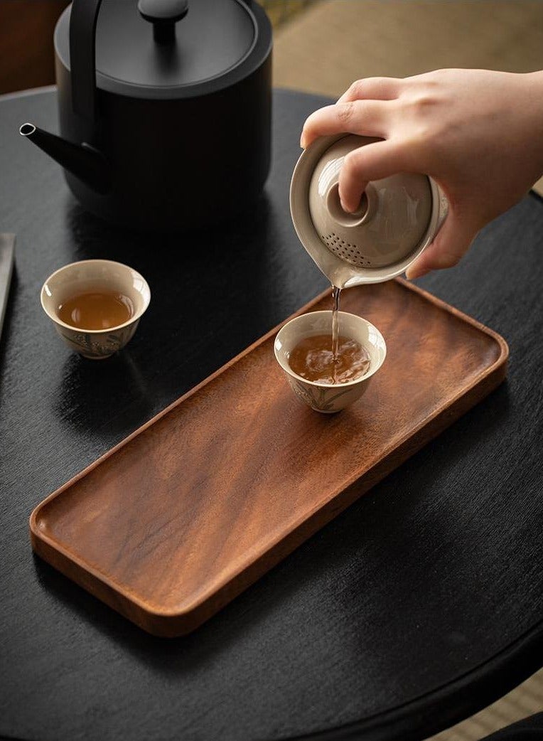 Pouring tea on acacia wood tray