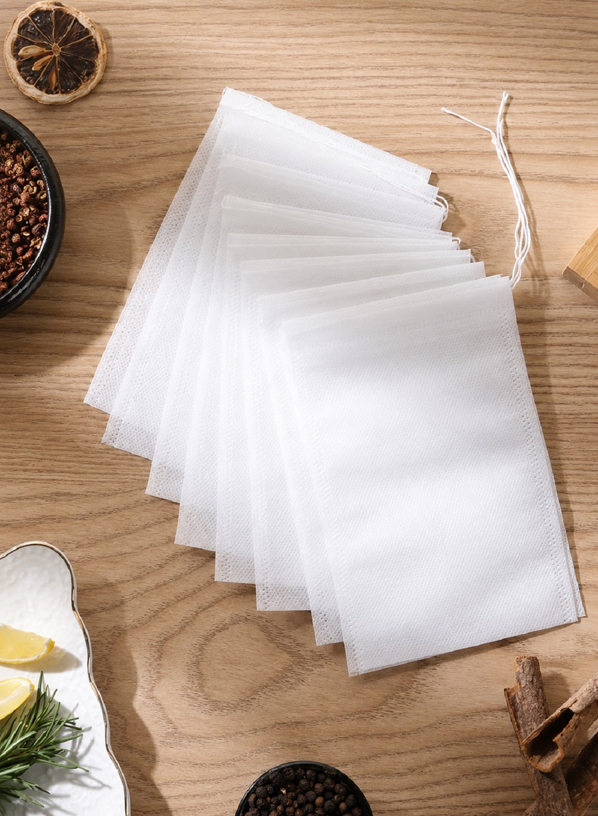 Fan of tea filter bags on wooden surface with spices