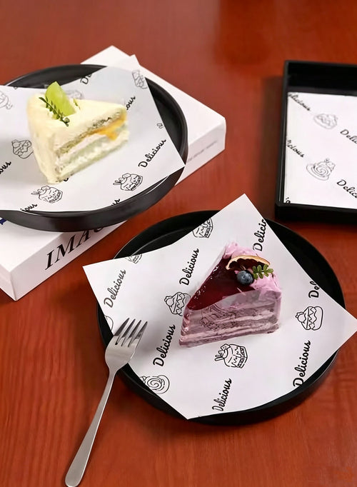 Printed wax paper sheets with cake slices on black plates